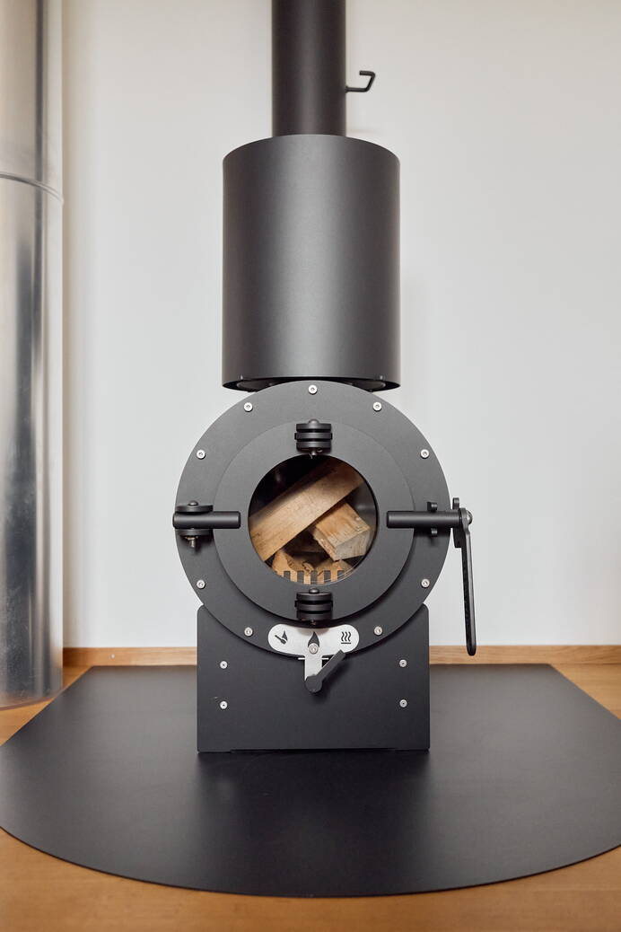 Schwedenofen Firetube Shorty slick, 360° drehbar Stahl schwarz, Grundmodul, Sockel 60 mm hoch Montagebeispiel